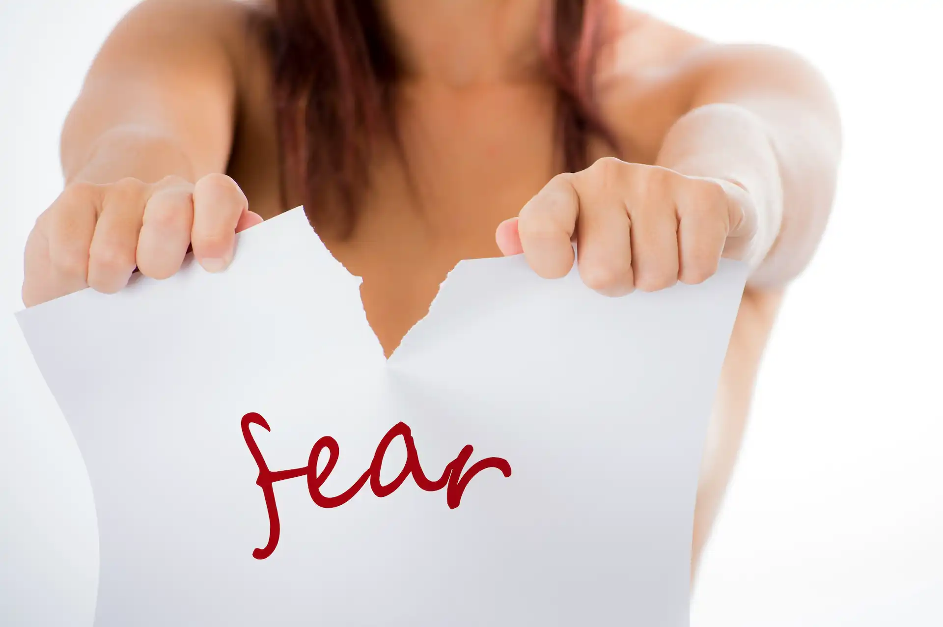 women is ripping a paper sheet with a word fear
